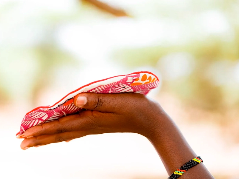 Woman's hand holding a locally designed Padmad reusable pad