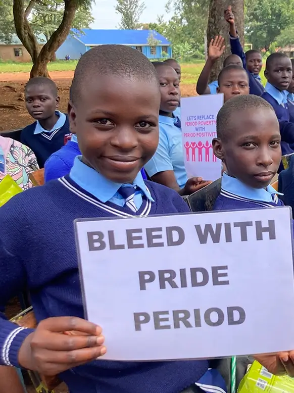 Confident girl holding a 'Bleed with Pride' sign at Padmad event